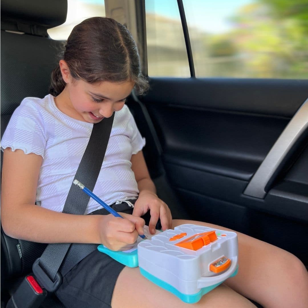ילדה מציירת באמצעות מקרן חכם לדרך !smART Sketcher® GO תוך כדי נסיעה ברכב